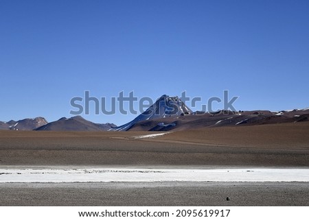 A landscape with salt flats and a volcano in the background, Atacama desert, northern Chile
