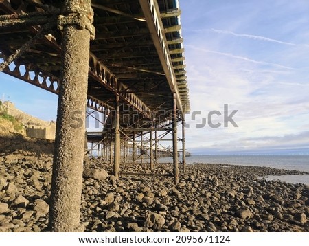 A pier, and pebbles at the seaside in Llandudno, Wales, the UK