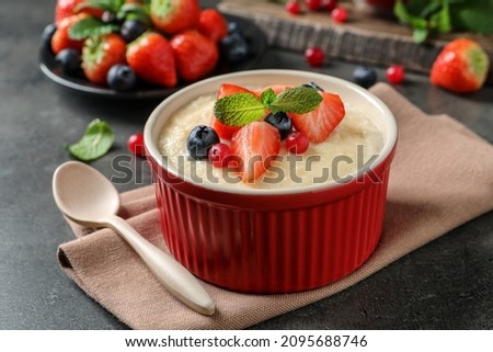 Delicious semolina pudding with berries and mint served on grey table Royalty-Free Stock Photo #2095688746