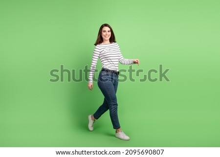 Full body profile side photo of young attractive woman go wear casual clothes isolated over green color background
