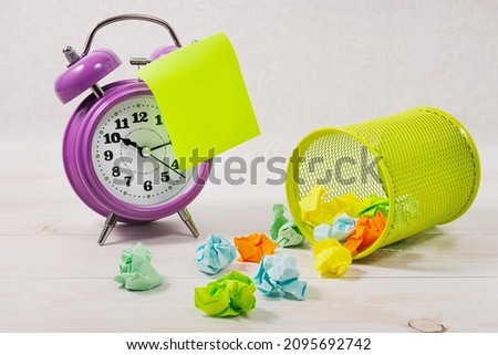 On the desktop is an alarm clock with a blank yellow sticker, pencil holder, crumpled paper. The concept of searching for ideas, business development, training.