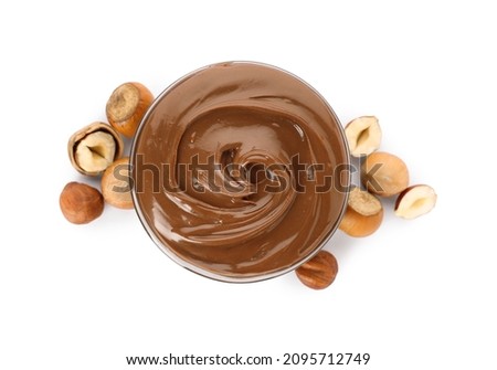 Tasty chocolate hazelnut spread and nuts on white background, top view Royalty-Free Stock Photo #2095712749