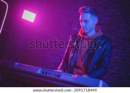 A musician is playing on the synthesizer at the scene. Royalty-Free Stock Photo #2095718449
