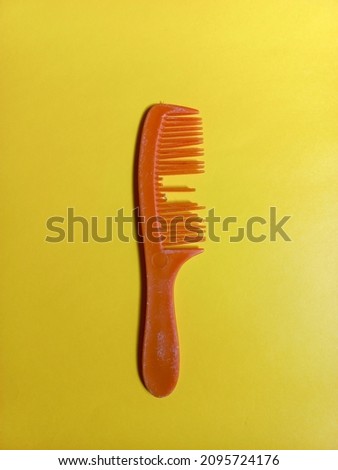 plastic hair comb, bone or horn is broken on the yellow background