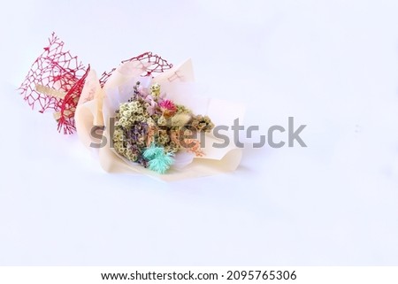 Hand bouquet made with artificial flowers isolated on white background