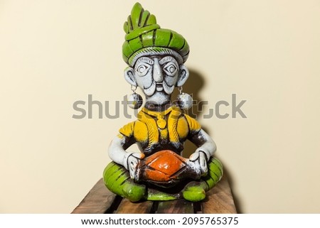 Handmade colorful musician sculpture made with clay with plain background.