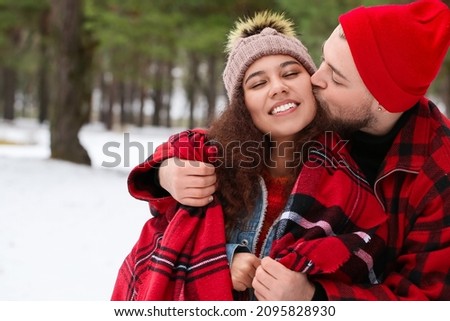 Happy young couple in forest on winter day