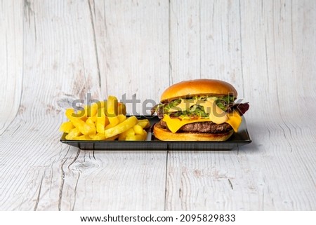 Premium burger with french fries on wooden table