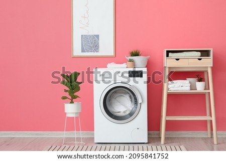 Interior of stylish bathroom with modern washing machine