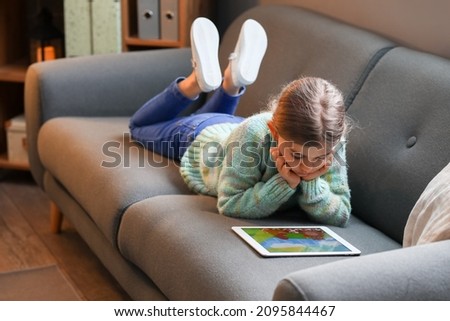 Cute girl watching cartoons at home