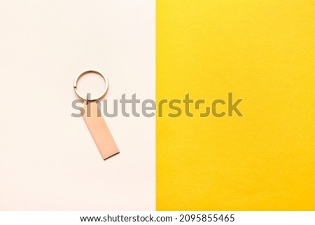 Stylish keychain on color background