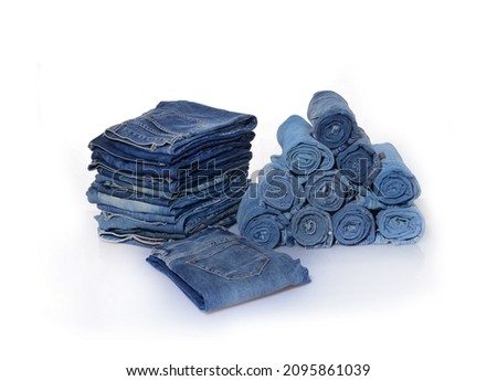 fashion clothing concept roll blue denim jeans arranged in stack

