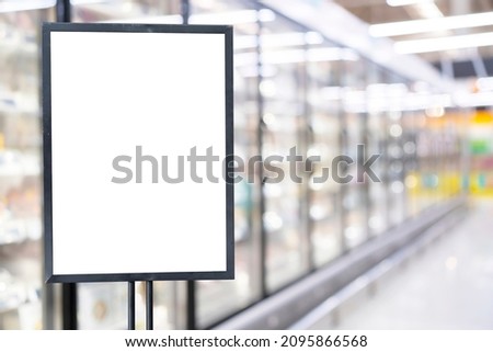 Blank poster frame template in supermarket. Blurred background and green filter of supermarket or grocery for price
