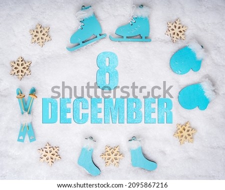 December 8th. Sports set with blue wooden skates, skis, sledges and snowflakes and a calendar date. Day 8 of month. Winter sports concept. Winter month, day of the year concept.