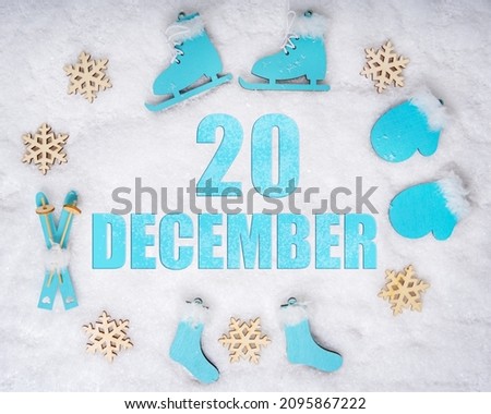 December 20th. Sports set with blue wooden skates, skis, sledges and snowflakes and a calendar date. Day 20 of month. Winter sports concept. Winter month, day of the year concept.