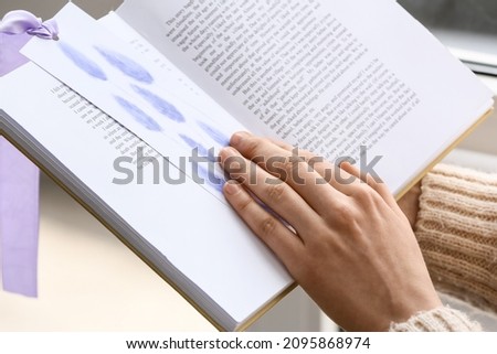 Woman reading book in room, closeup