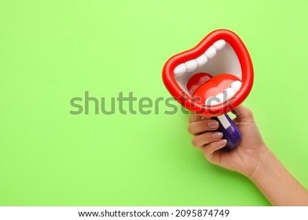 Woman with toy megaphone on green background