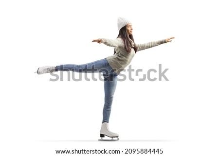 Full length shot of a young casual woman ice skating with one leg up isolated on white background