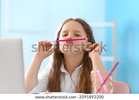 Little girl with pencil at home