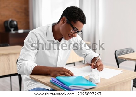African-American student passing exam at school Royalty-Free Stock Photo #2095897267