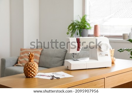 Tailor's workplace with sewing machine and sketches in atelier Royalty-Free Stock Photo #2095907956