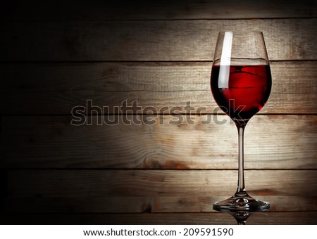Glass of red wine on a young wooden background