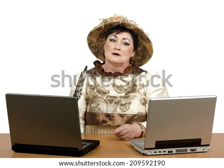 Picture of cautious old woman wearing costume of the early 20th century looks at computer