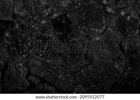 Many black stones arranged in layers looks mysterious. It may be a cave wall, used as a background, suitable for institutions and karma and design work, or suitable for geological work.