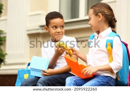 Cute little pupils having lunch outdoors Royalty-Free Stock Photo #2095922260