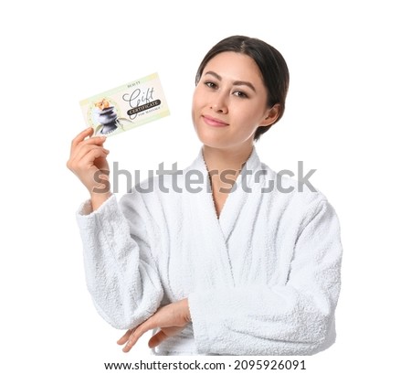 Young Asian woman with gift certificate for massage on white background
