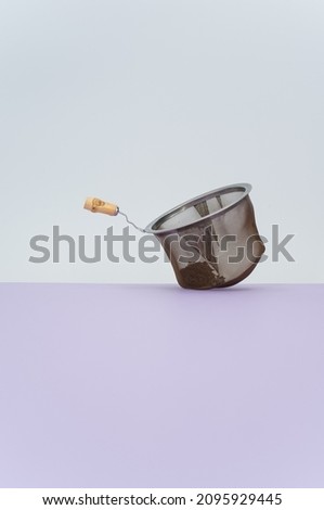 metal tea strainer on a lilac tabletop background with text space