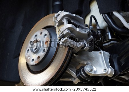 A close-up shows the brake caliper installed on a modern car.