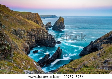 The coastline of Cornwall, England. A summers evening and the sky is glowing as the sun sets over the spectacular, rugged coastline Royalty-Free Stock Photo #2095948786