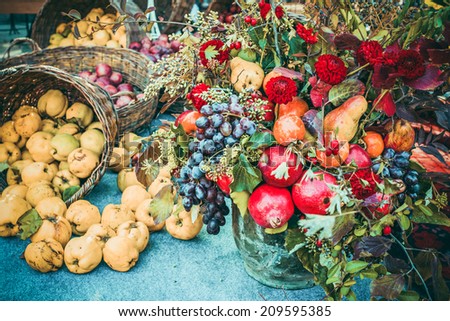 Autumn bouquet and quinces in basket on blue fabric. Toned picture