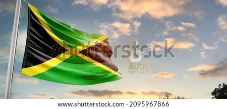Jamaica national flag cloth fabric waving on the sky with beautiful sky - Image