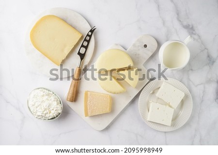 Various cheese types on marble and porcelain plates - ingredients for traditional georgian open pie khachapuri Royalty-Free Stock Photo #2095998949