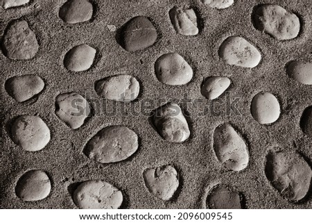 Brown background of pebbles in concrete. Big pebbles in the concrete mixture. Texture of pebbles for poster, branding, calendar, card, banner, cover, space for your design or text. High quality photo