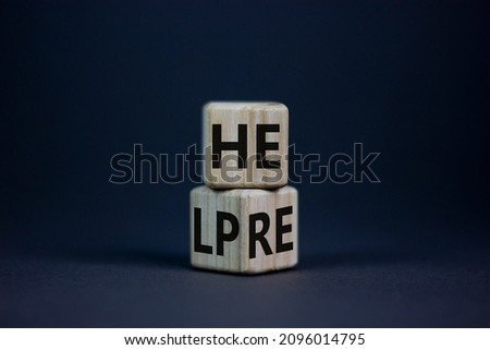 Help is here and support symbol. Turned cubes and changed the word help to here. Beautiful grey table, grey background, copy space. Business, motivational, support and help is here concept.
