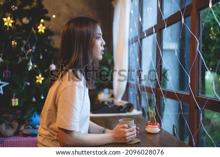 young Asian woman are happy and enjoy to celebrate for Christmas eve in cafe, Christmas party light background showing in coffee cafe