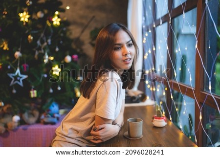 young Asian woman are happy and enjoy to celebrate for Christmas eve in cafe, Christmas party light background showing in coffee cafe