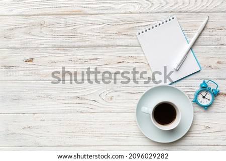 Modern office desk table with notebook and other supplies with cup of coffee. Blank notebook page for you design. Top view, flat lay.