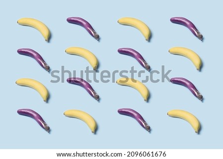 Bananas and Japanese eggplants arranged in a symmetrical pattern. Minimal vegetarian top view concept