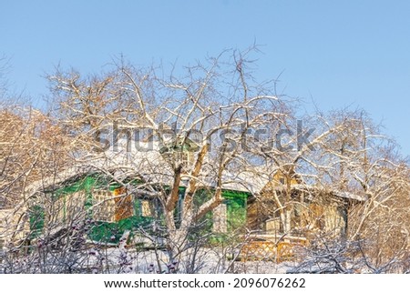 Wooden green house on a hillock on a winter day