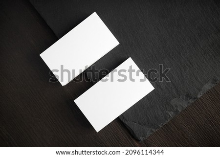 Blank white business cards on stone board. Mockup for ID. Template for graphic designers portfolios. Flat lay.