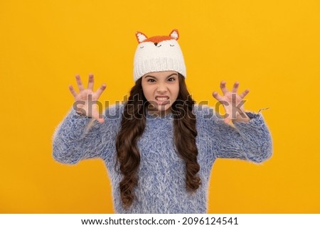 winter fashion. spooky kid with curly hair in hat. female fashion model.