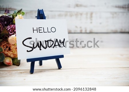 Hello Sunday text with flower bouquet on wooden background