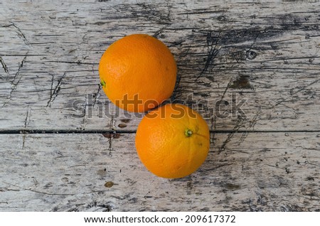 Two orange fruits over an aged wooden table