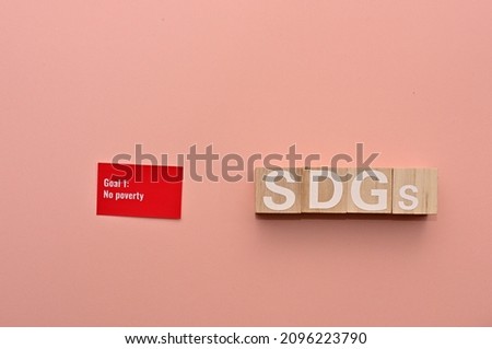Wooden cubes arranged in the letters of the SDGs and a card with the Goal 1: No poverty of one of the Sustainable Development Goals written on it.”