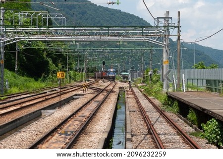 Joetsu Line running in Uonuma City, Niigata Prefecture.Translation: Below the signal, "Wireless switching?" "Departure" is written, and in the lower right box, "Up main line" is written. Royalty-Free Stock Photo #2096232259