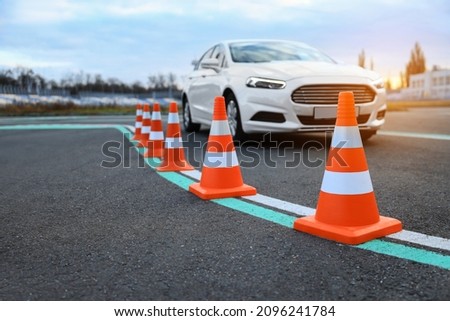 Modern car at test track, focus on traffic cone. Driving school Royalty-Free Stock Photo #2096241784